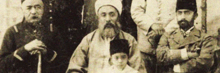 A formal sepia photograph of Abu Bakr Effendi seated among several of his children in nineteenth-century dress.