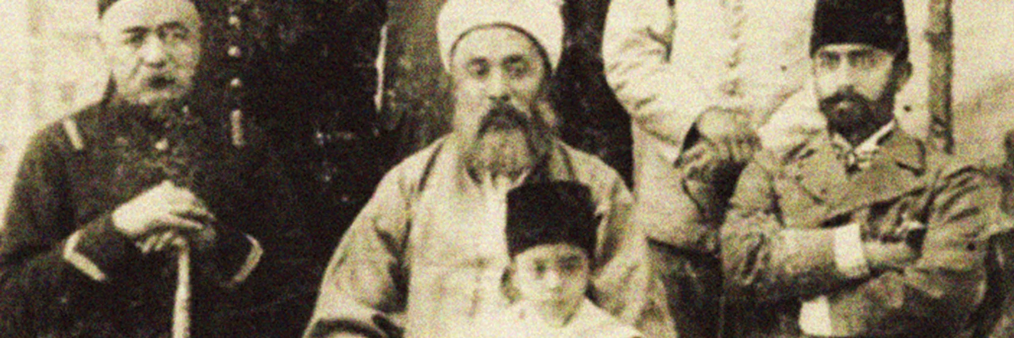 A formal sepia photograph of Abu Bakr Effendi seated among several of his children in nineteenth-century dress.