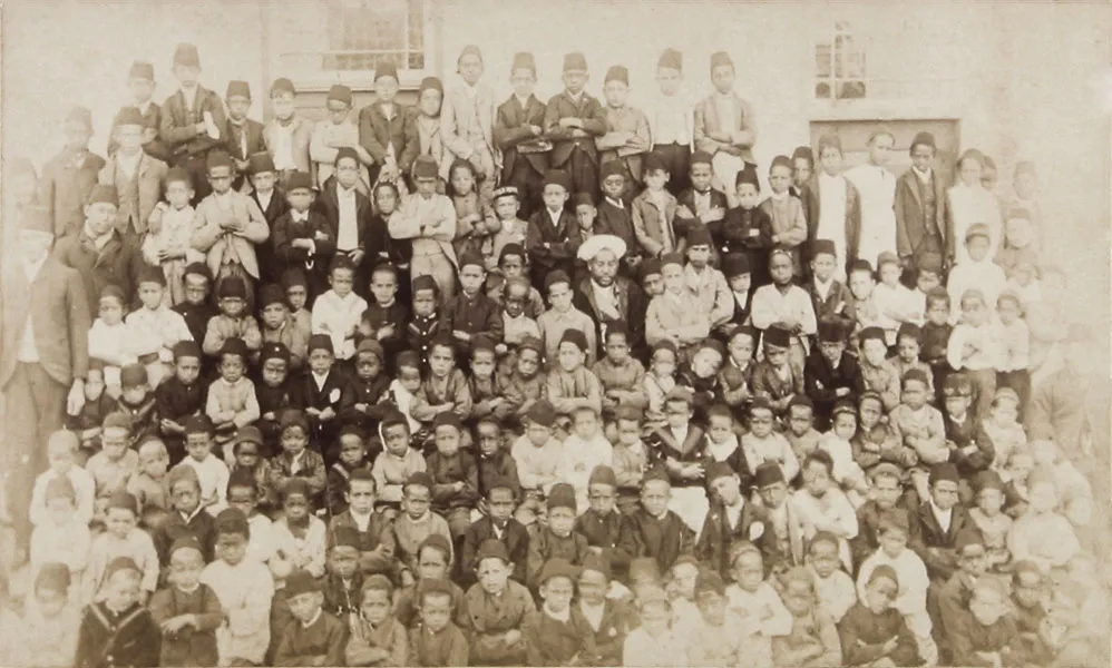An 1895 group photograph of the teachers and students of the Islamic school in Kimberley, posed in rows outside the school building.