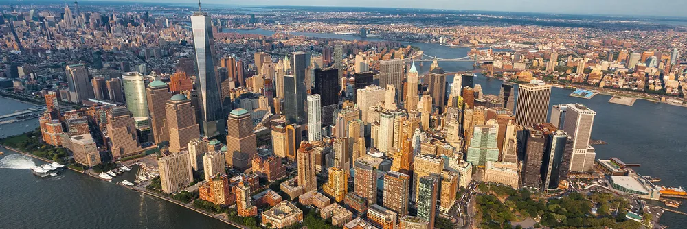 The famous Manhattan skyline seen across the water, its towers crowded along the tip of the island that was once New Amsterdam.