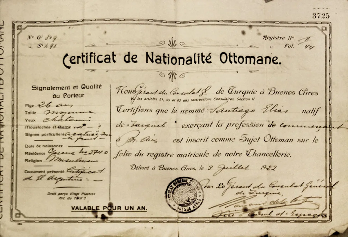 An Ottoman certificate of nationality, printed in French, with elaborate borders and a handwritten personal photograph pasted into an oval frame.