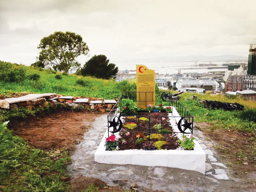A simple white-walled grave at the Tana Baru cemetery in Cape Town, with an engraved headstone.