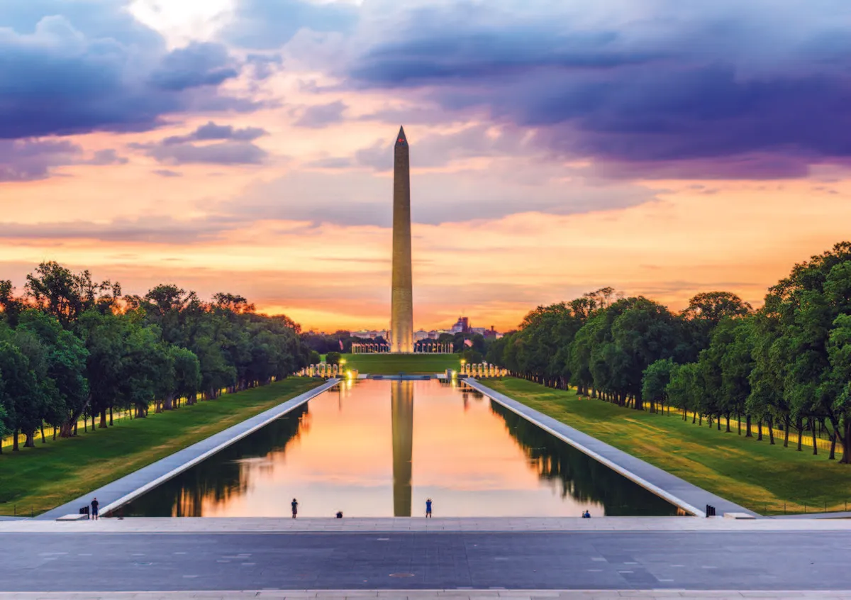 The Washington Monument, a tall white obelisk, rising against a clear sky.